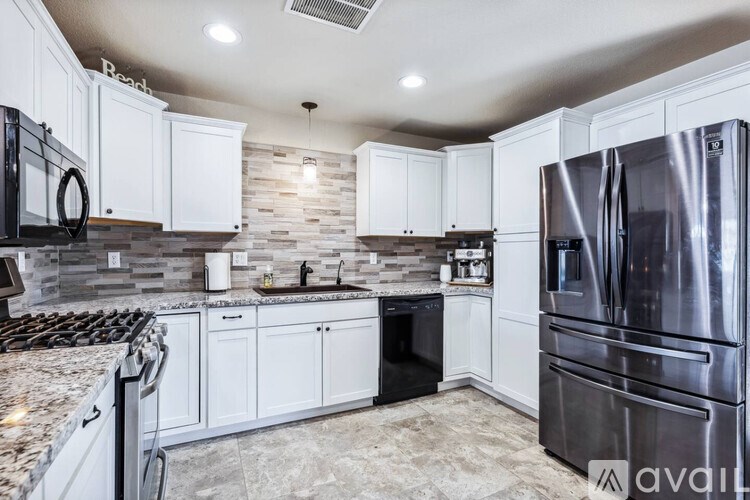 A kitchen with a granite countertop and stainless steel appliances.