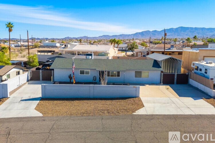 A house with a flag on the front and a mountain in the background.