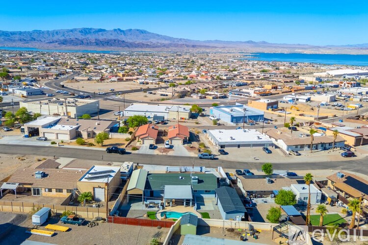 A bird's eye view of a town with a large body of water in the background.