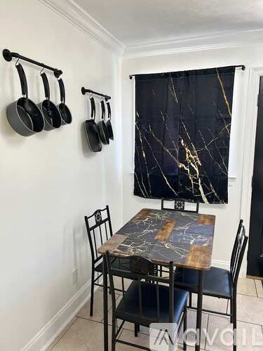 A kitchen with a marble table and chairs.