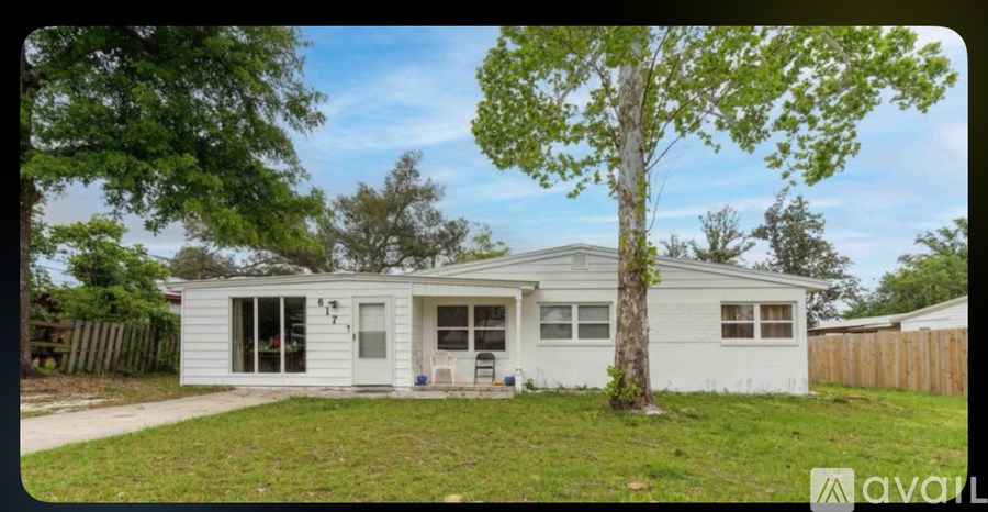 A white house with a tree in front of it.