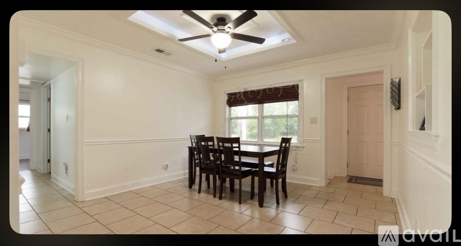 A dining room with a table and chairs.