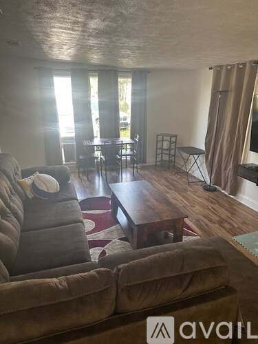 A living room with a brown couch and a wooden coffee table.