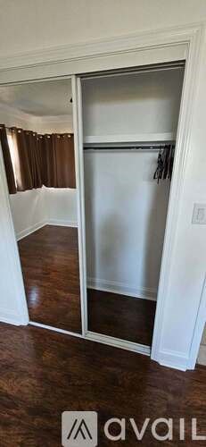 A white closet with a sliding door is open.