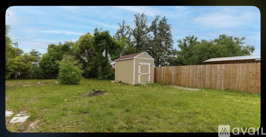 A small shed sits in a grassy backyard.