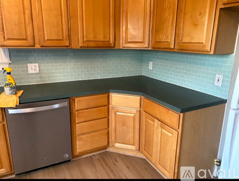 A kitchen with wooden cabinets and a black countertop.