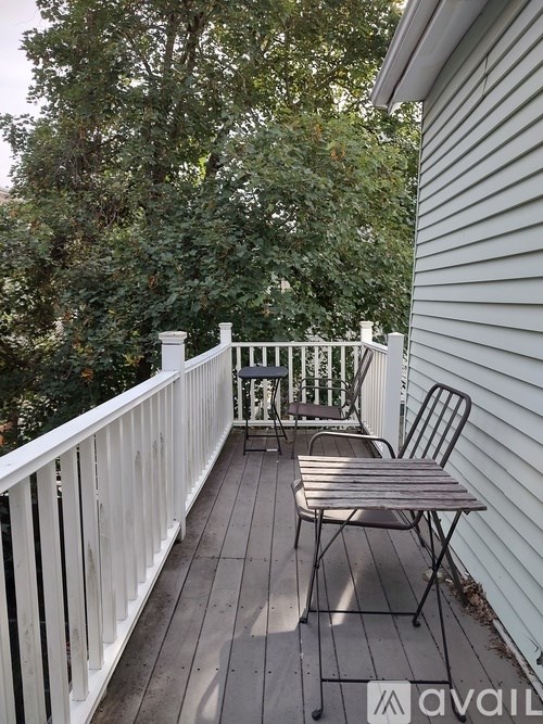 A white chair is on a wooden deck.
