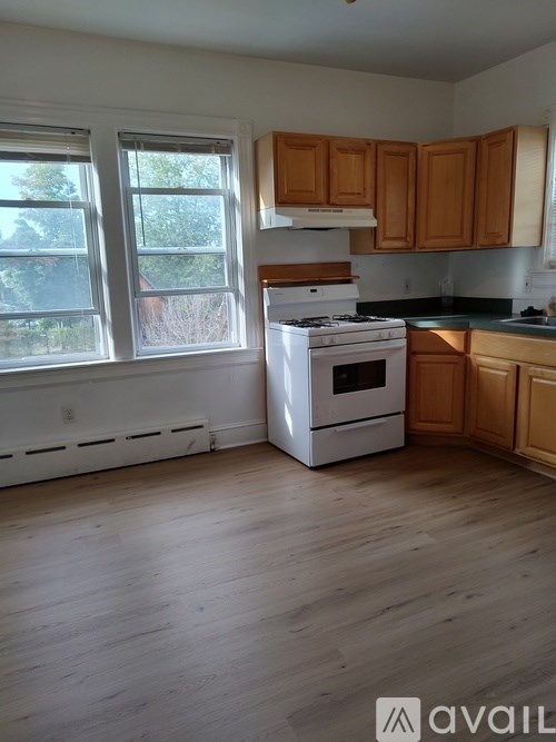 A kitchen with wooden cabinets and a white stove.