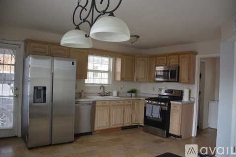 A kitchen with wooden cabinets and a stainless steel refrigerator.