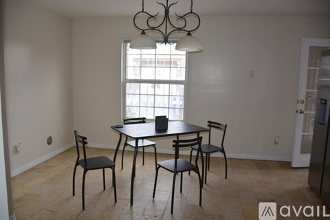 A dining room with a table and chairs.