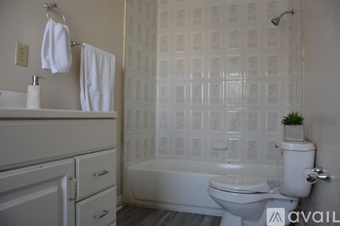 A white towel hangs on a towel ring in a bathroom.