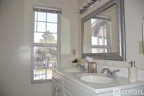 A bathroom with a large mirror and a window.