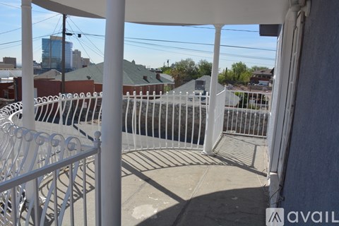 A balcony with a metal railing and a view of the city.