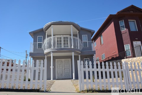 A house with a white picket fence in front.