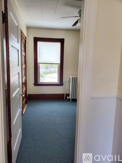 A room with a window and a fan on the ceiling.