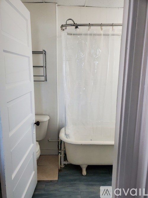 A white bathroom with a toilet, tub and shower curtain.