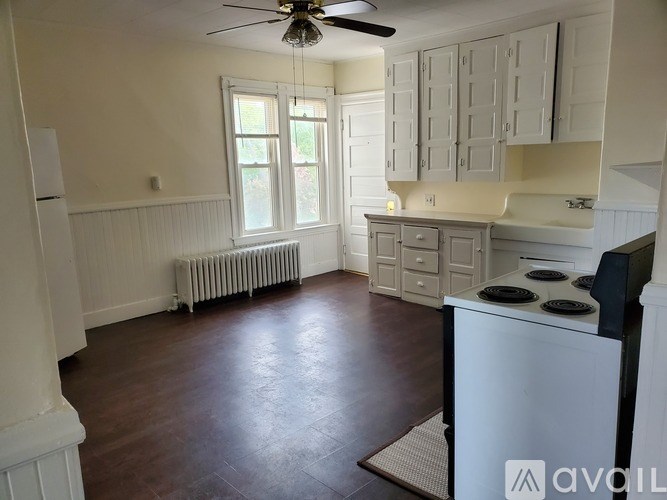 A kitchen with white cabinets and a black stove top oven.