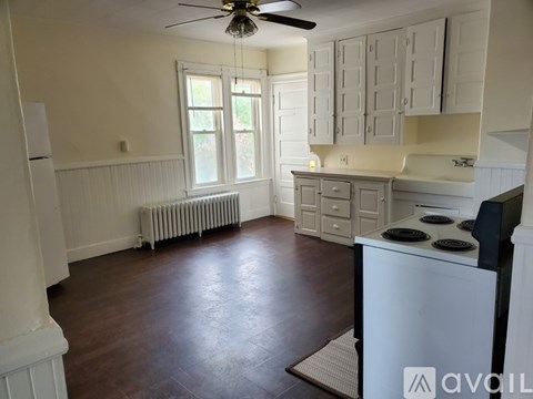 A kitchen with white cabinets and a black stove top oven.
