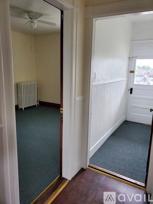 A room with a carpeted floor and a white door.