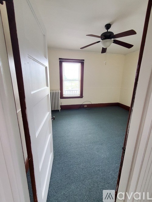 A room with a ceiling fan and a window.