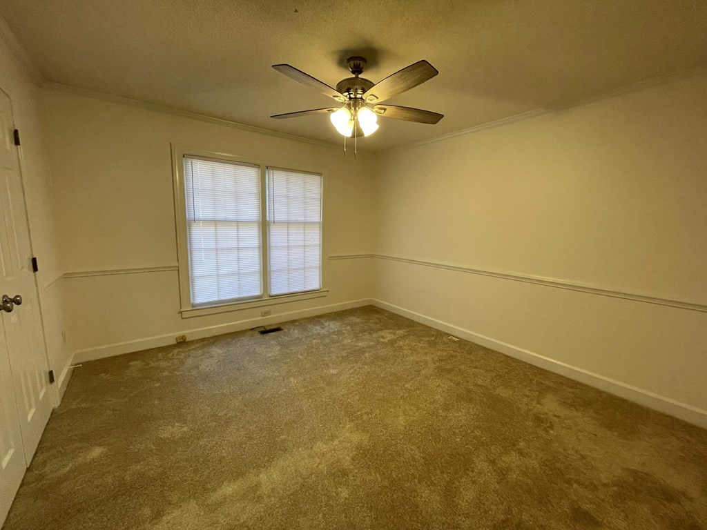 A room with a ceiling fan and a window.