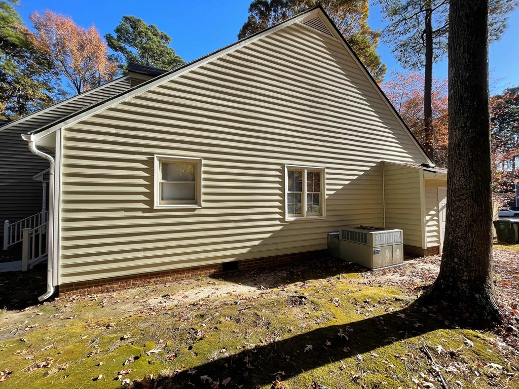 A house with a grey siding and a white window.