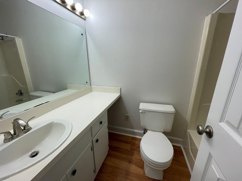 A white toilet sits next to a sink in a small bathroom.
