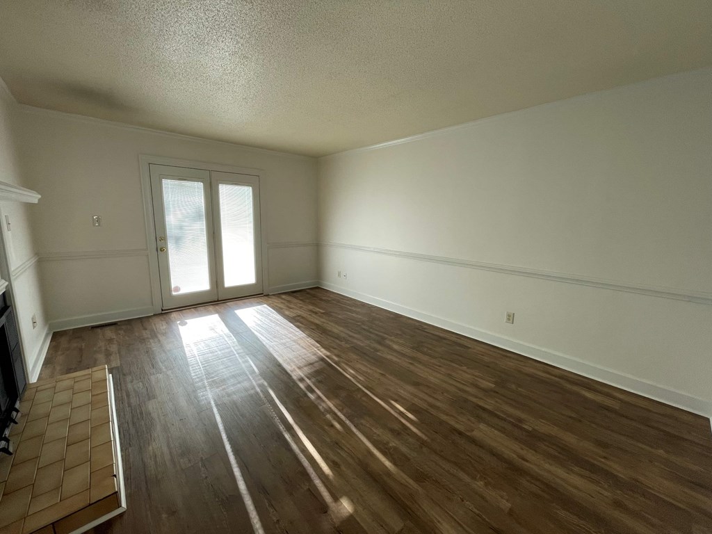 A room with wooden floors and a sliding glass door.
