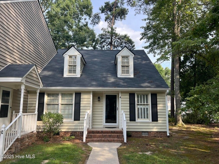 A small house with a black roof and white trim.