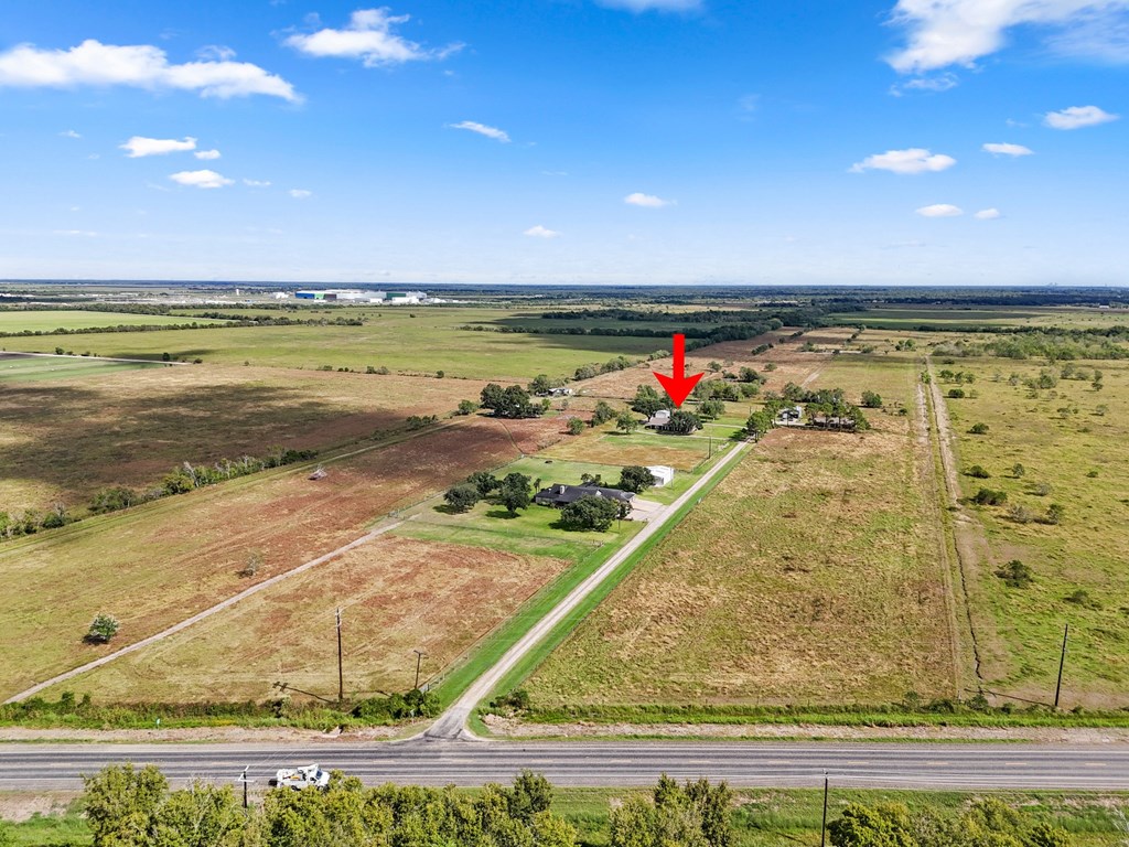A red arrow points to a small building in a field.