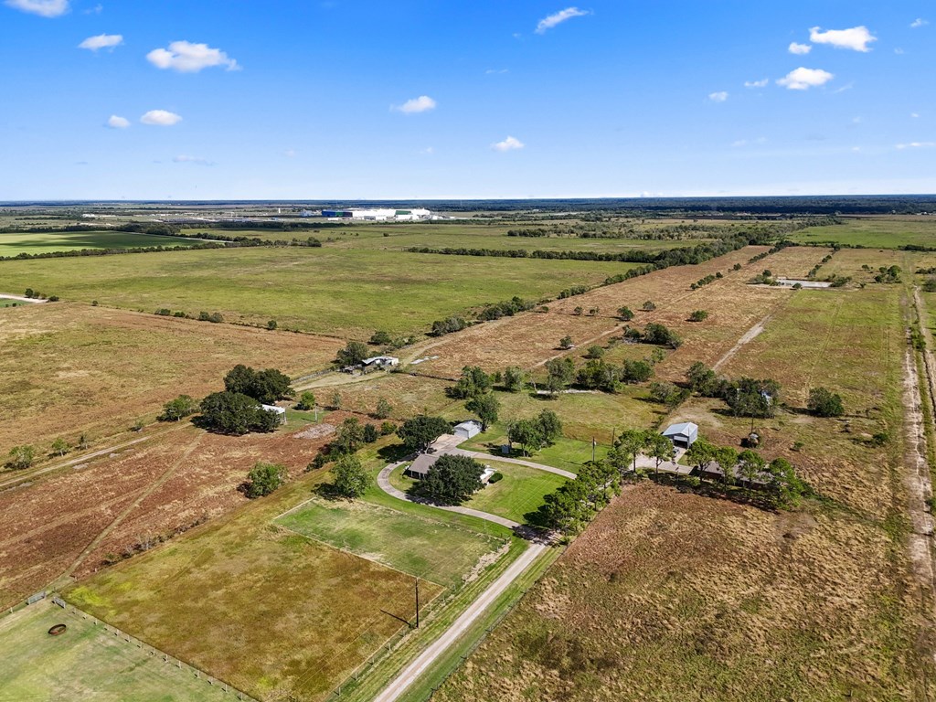 A rural landscape with a house and trees.
