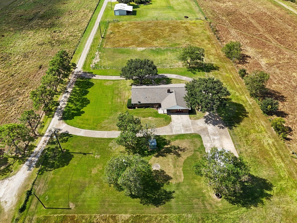 A house with a green lawn and trees in front of it.