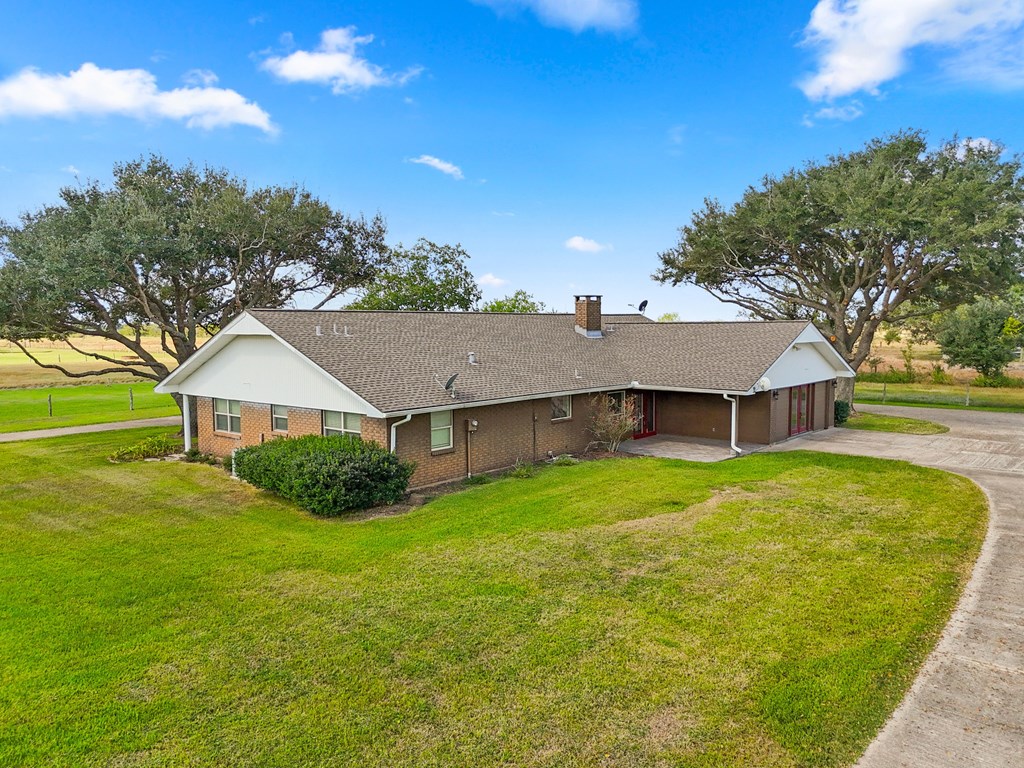 A house with a brown roof and a green lawn.