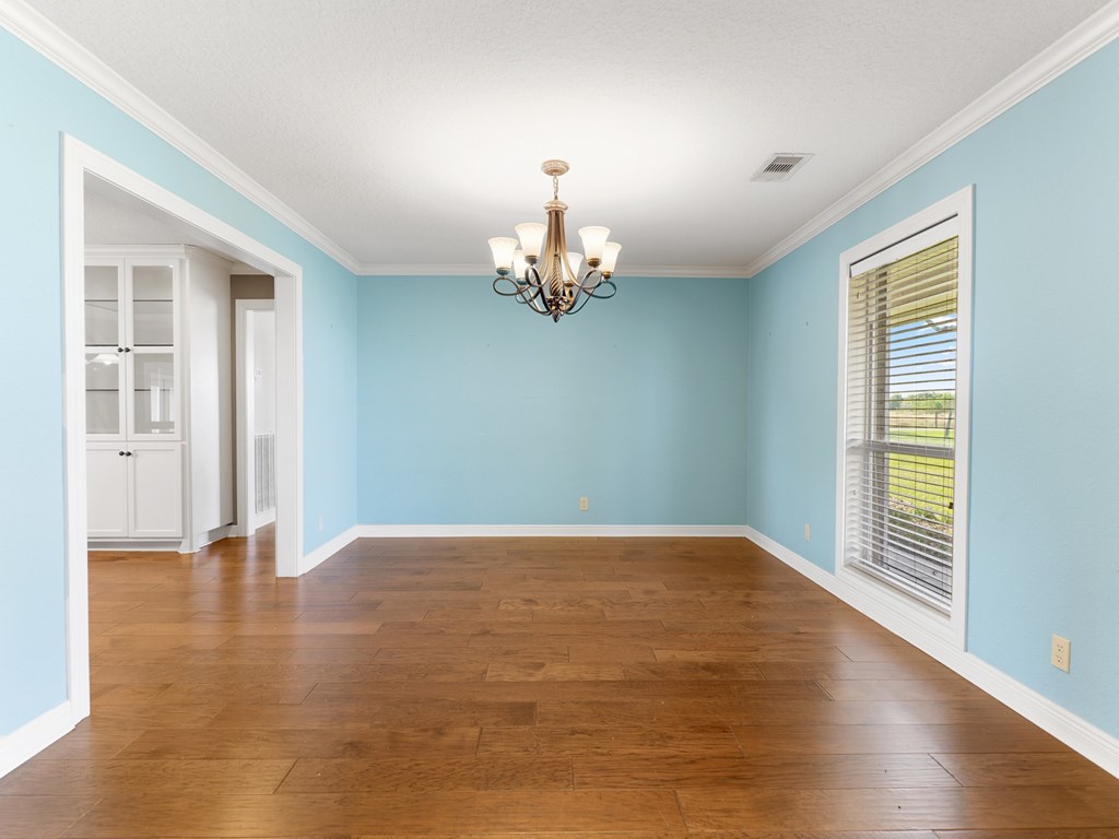 A room with wooden floors and a chandelier.