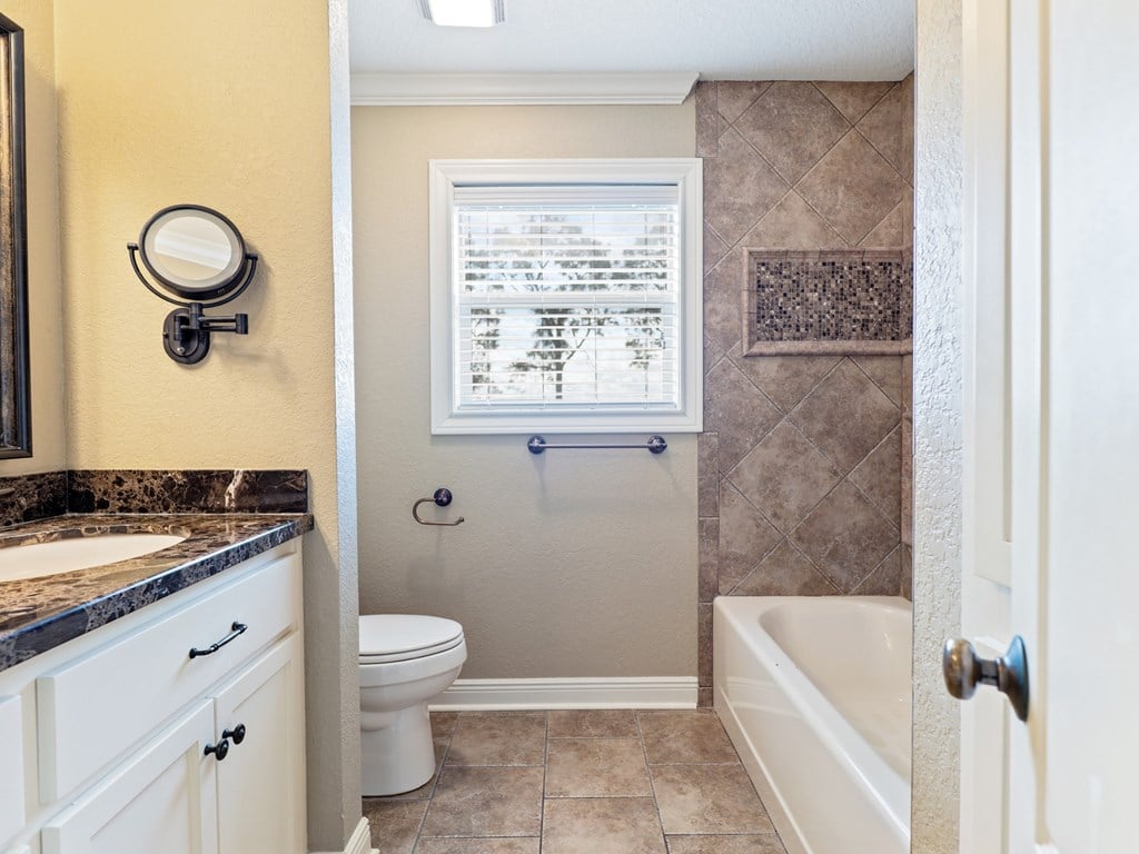 A bathroom with a toilet, sink, and bathtub.