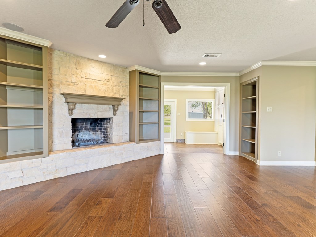 A room with a fireplace and wood floors.