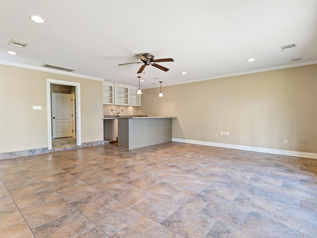 A room with a ceiling fan and tile flooring.