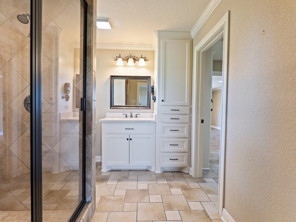 A bathroom with a white vanity and a mirror above it.