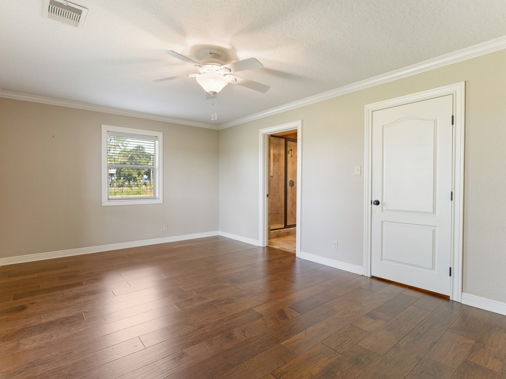 A room with wooden floors and a ceiling fan.