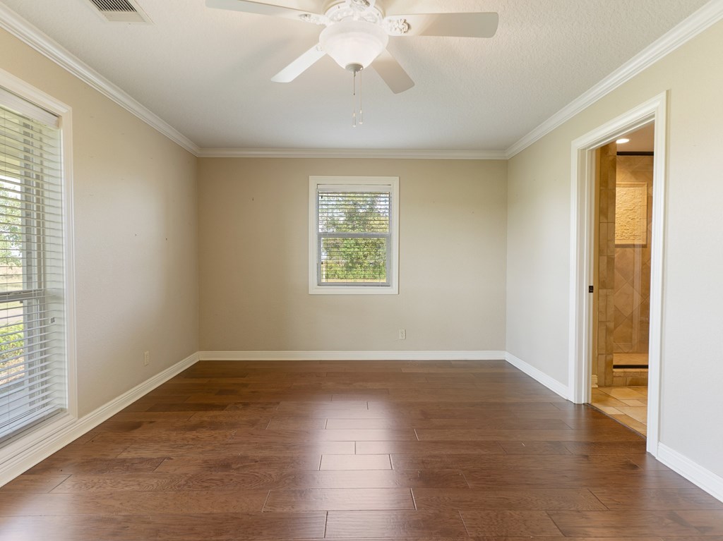 A room with a ceiling fan and a window.