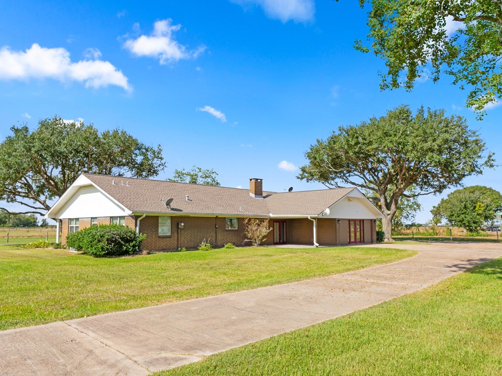 A house with a driveway and trees in the background.