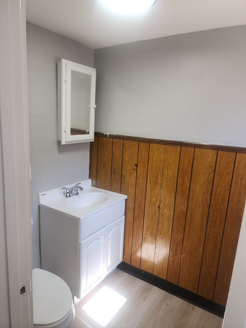 A white sink and toilet in a small bathroom.