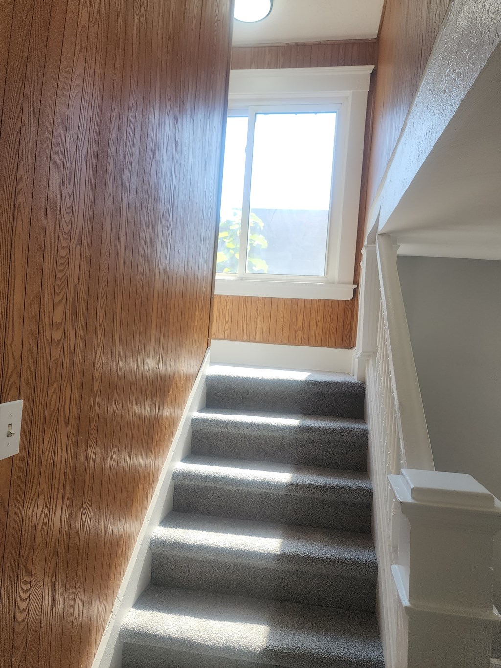 A staircase with a light on the side.