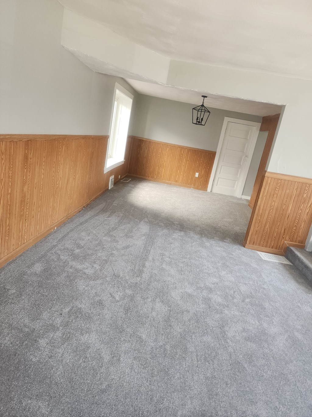 A room with wooden paneling and a carpeted floor.