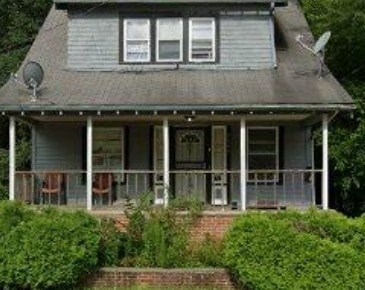 A house with a grey roof and white porch.
