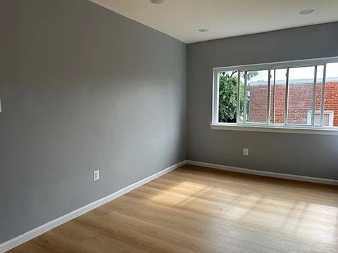 A room with a window and wooden flooring.