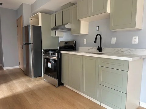 A kitchen with a stainless steel refrigerator and oven.