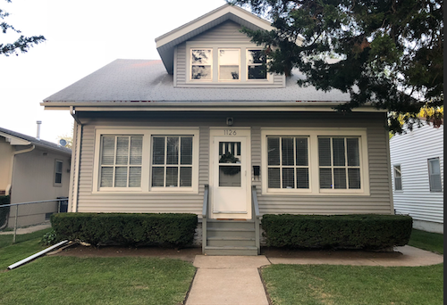 A house with a grey roof and a white door.