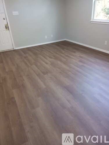 A room with wooden flooring and a white door.