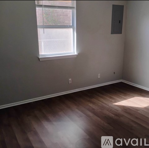 A room with wooden flooring and a window.